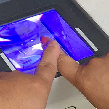 Photo of a person's finger being printed for LiveScan Fingerprinting at Maloney Security office